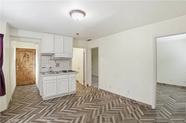 a kitchen with granite countertop a sink stove and refrigerator