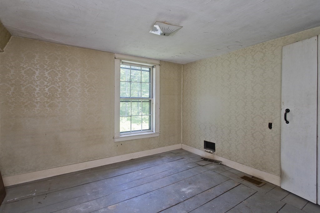 806 Colebrook River Road Tolland, MA 01034 - Photo 14 of 17 an empty room with wooden floor and windows