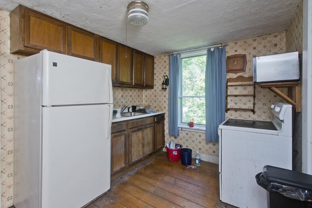 806 Colebrook River Road Tolland, MA 01034 - Photo 3 of 17 a kitchen with a refrigerator a stove a sink dishwasher and wooden cabinets with wooden floor