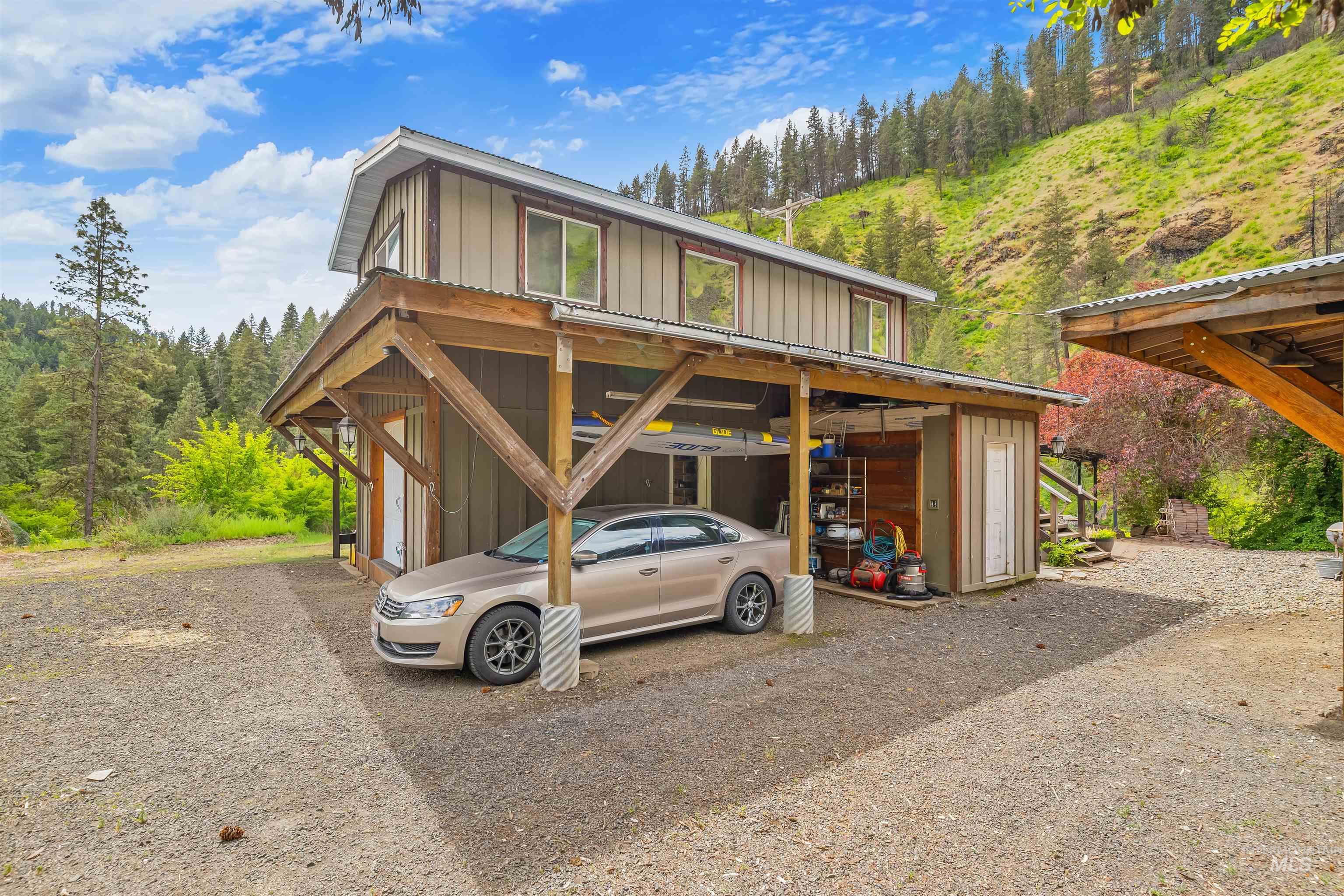 1314 Cedar Ridge Road Kendrick, ID 83537 - Photo 6 of 50 Two-story structure featuring a ground-level carport with exposed wood beam supports and a corrugated metal roof