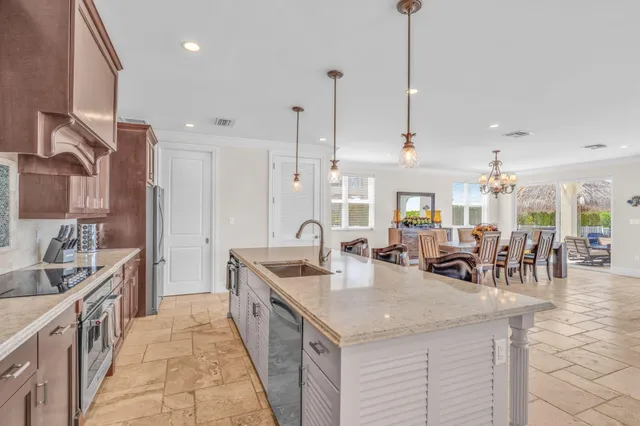 a view of a dining room with furniture a chandelier and large windows