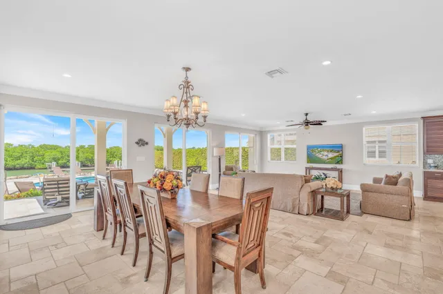 a living room with furniture kitchen view and a chandelier