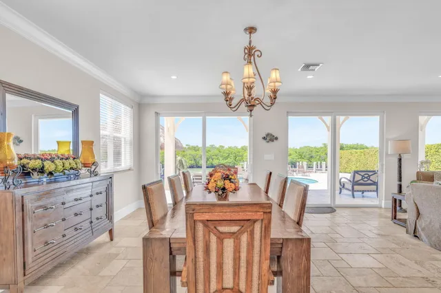 a dining room filled chandelier and kitchen view