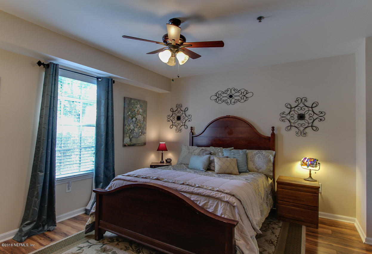23583 Bahama Point Fernandina Beach, FL 32034 - Photo 13 of 37 a bedroom with a bed and a chandelier