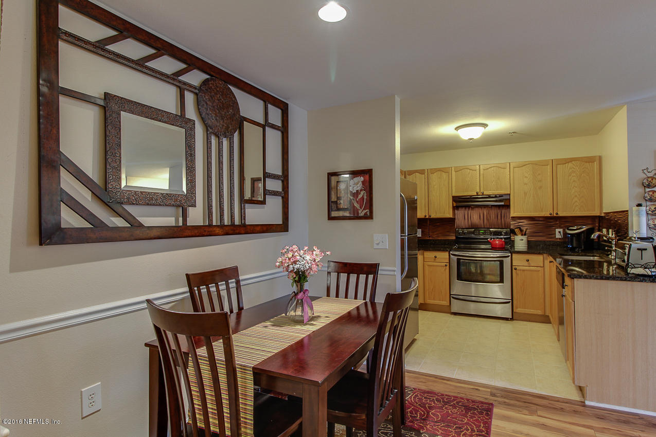 23583 Bahama Point Fernandina Beach, FL 32034 - Photo 10 of 37 a kitchen with stainless steel appliances kitchen island granite countertop a dining table chairs and a refrigerator