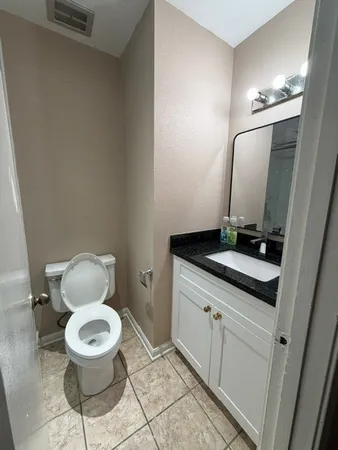 a bathroom with a toilet a sink and mirror