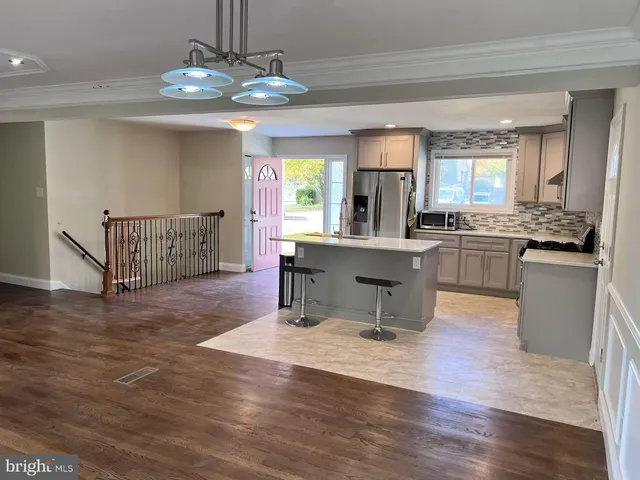 a living room with granite countertop furniture a dining table and chairs with wooden floor