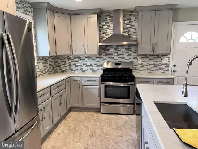 a kitchen with a stove a refrigerator and a sink