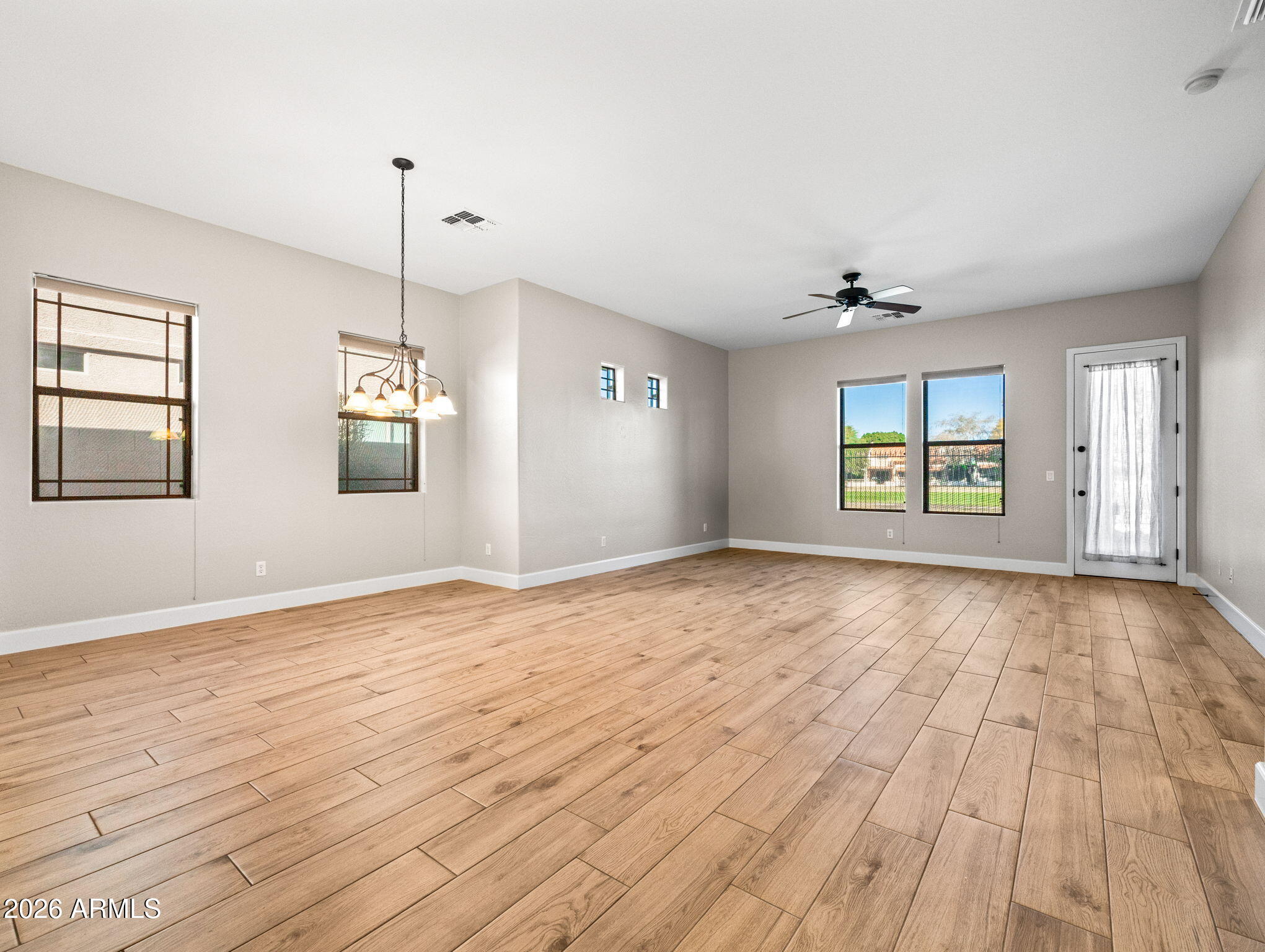 6202 East McKellips Road, Unit 83 Mesa, AZ 85215 - Photo 11 of 54 a view of an empty room with a window and wooden floor