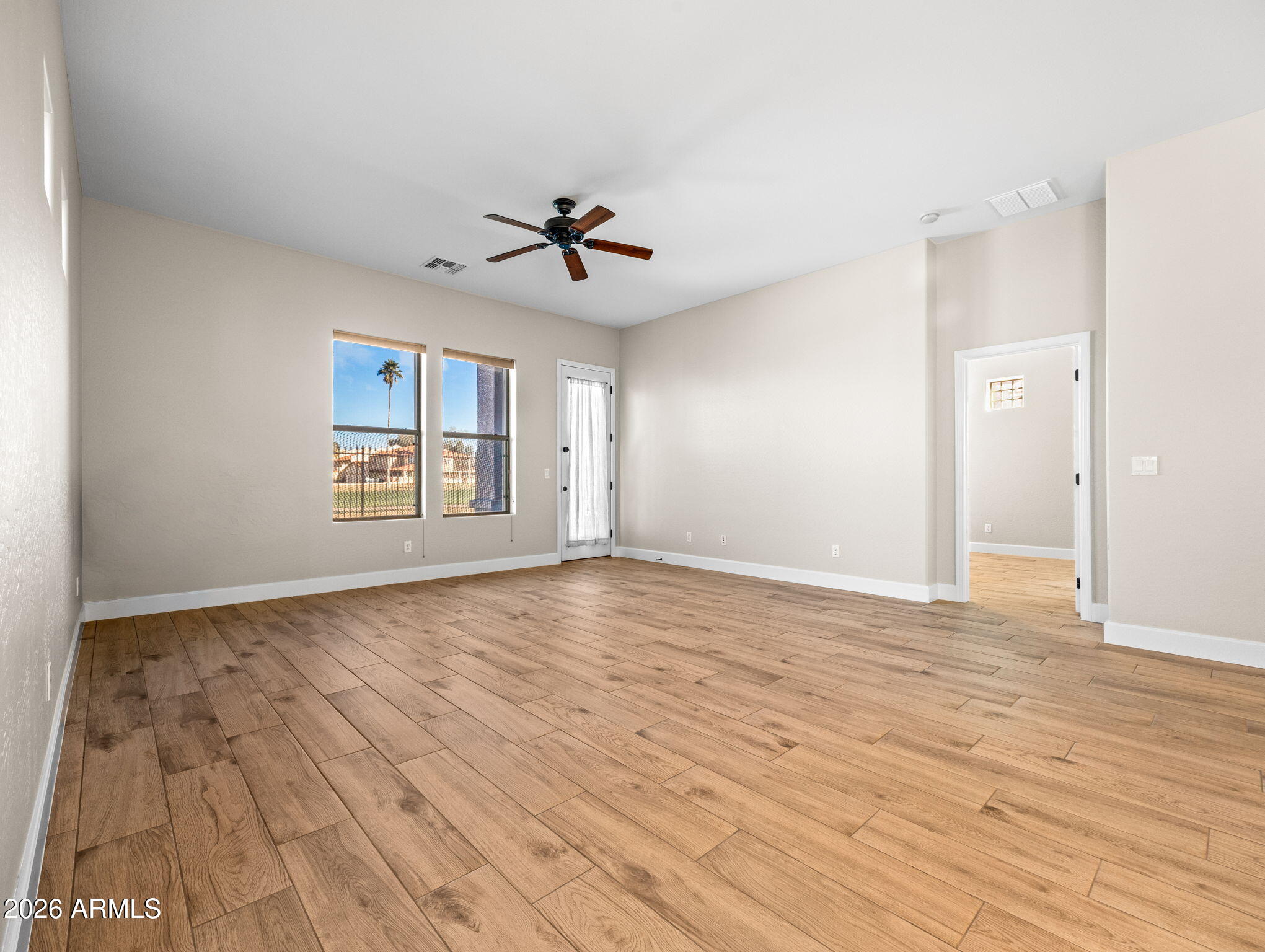 6202 East McKellips Road, Unit 83 Mesa, AZ 85215 - Photo 13 of 54 a view of empty room with wooden floor and fan