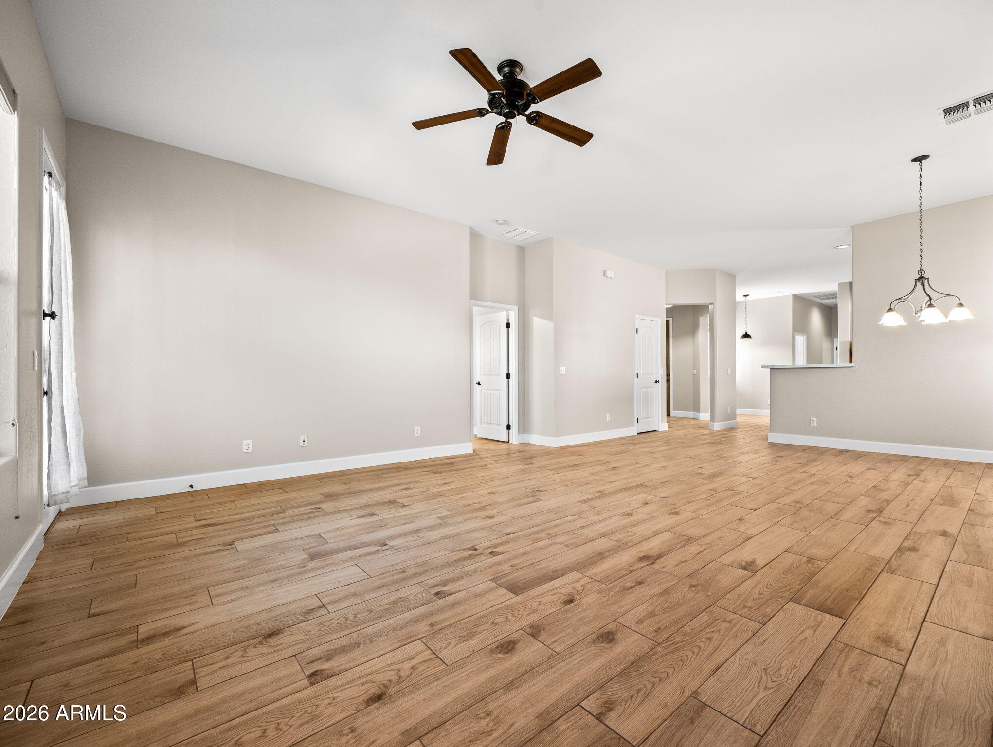 6202 East McKellips Road, Unit 83 Mesa, AZ 85215 - Photo 54 of 54 a view of empty room with wooden floor and ceiling fan