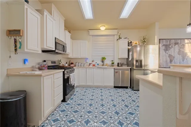 a kitchen with a sink a counter top space stainless steel appliances and cabinets