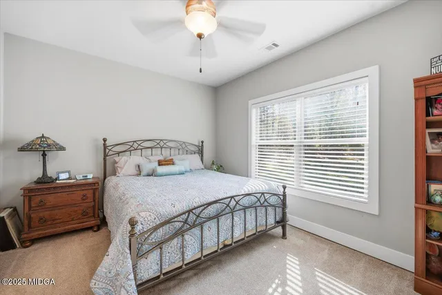 a living room with furniture a flat screen tv and a floor to ceiling window