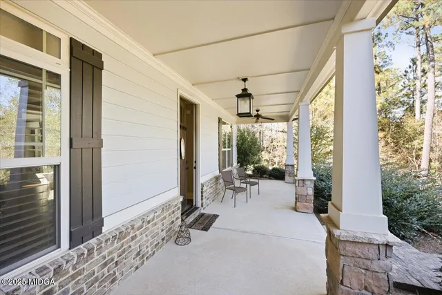 a view of a porch with chairs and backyard of the house