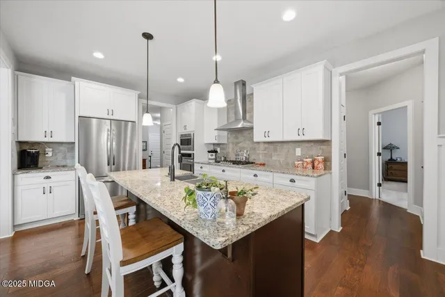 a large kitchen with stainless steel appliances granite countertop a sink stove and refrigerator
