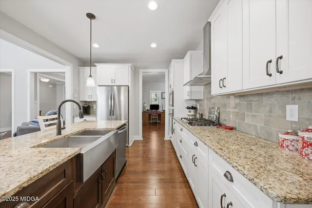 a kitchen with stainless steel appliances kitchen island granite countertop a table chairs sink and cabinets