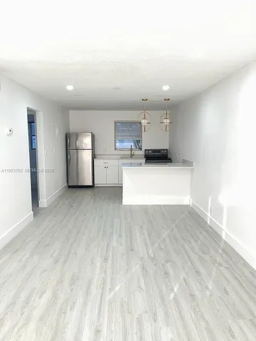 a view of kitchen and refrigerator