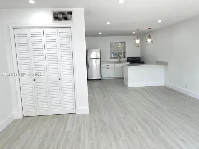 a view of kitchen with refrigerator sink and cabinets