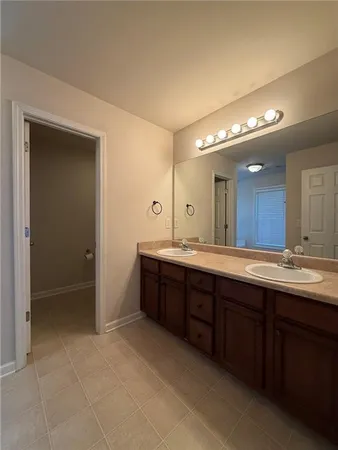 a spacious bathroom with a double vanity sink a mirror and a bathtub