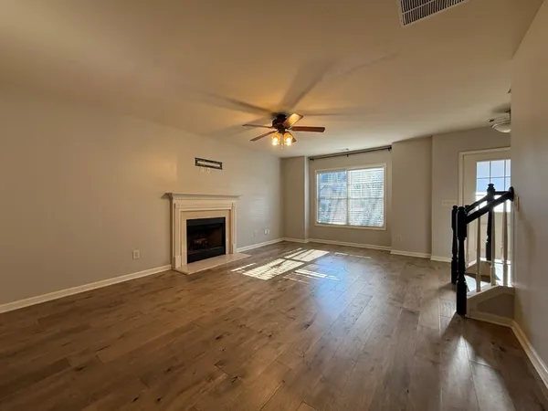 a view of an empty room with a fireplace and a window