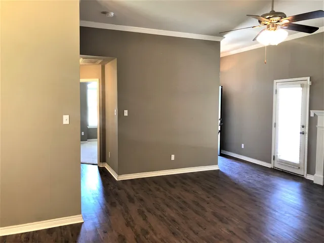 a view of an empty room with wooden floor