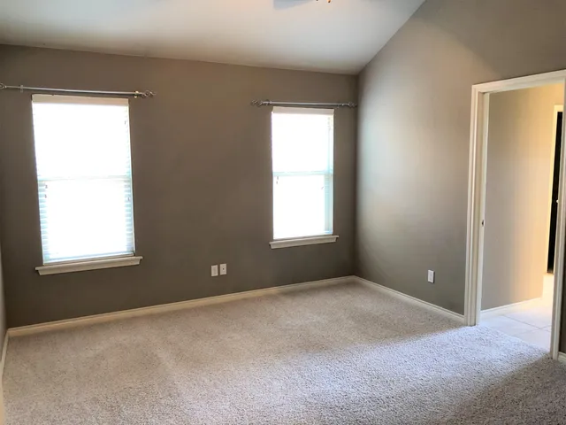 an empty room with windows and closet