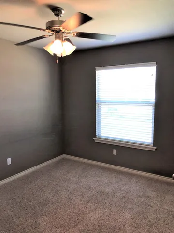 a view of a livingroom with a chandelier fan and a window