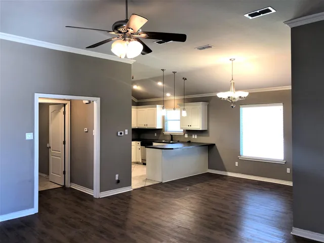 a view of a kitchen with a stove wooden floor and a window
