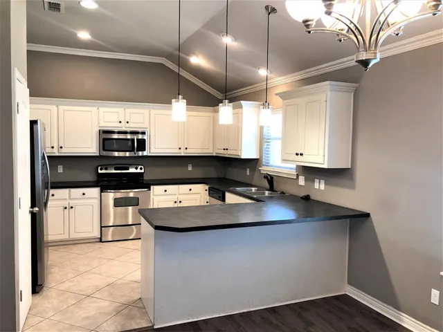 a kitchen with stainless steel appliances granite countertop a sink a stove and a microwave