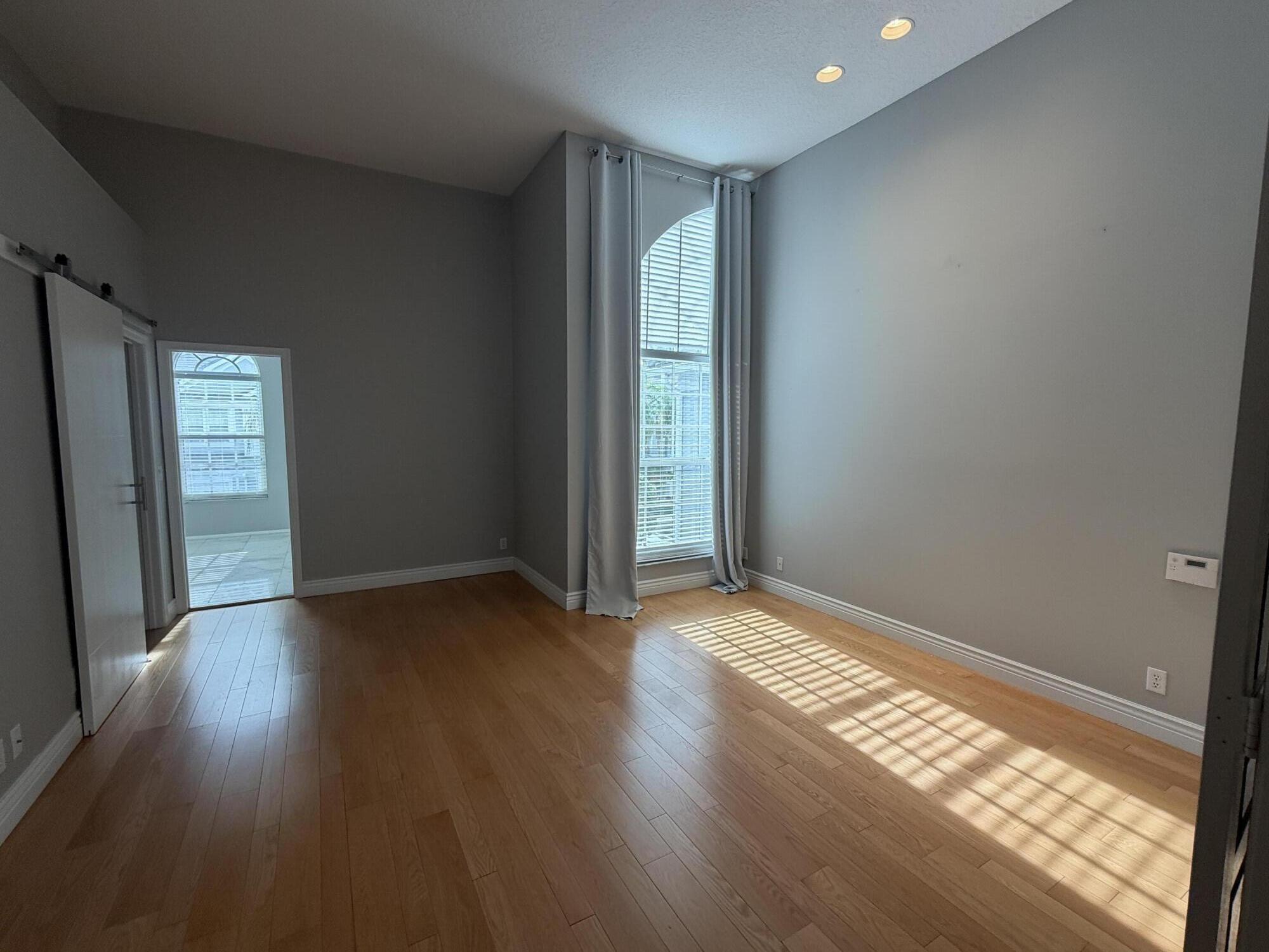 21543 St Andrews Grand Circle, Unit 41 Boca Raton, FL 33486 - Photo 14 of 27 an empty room with wooden floor and windows