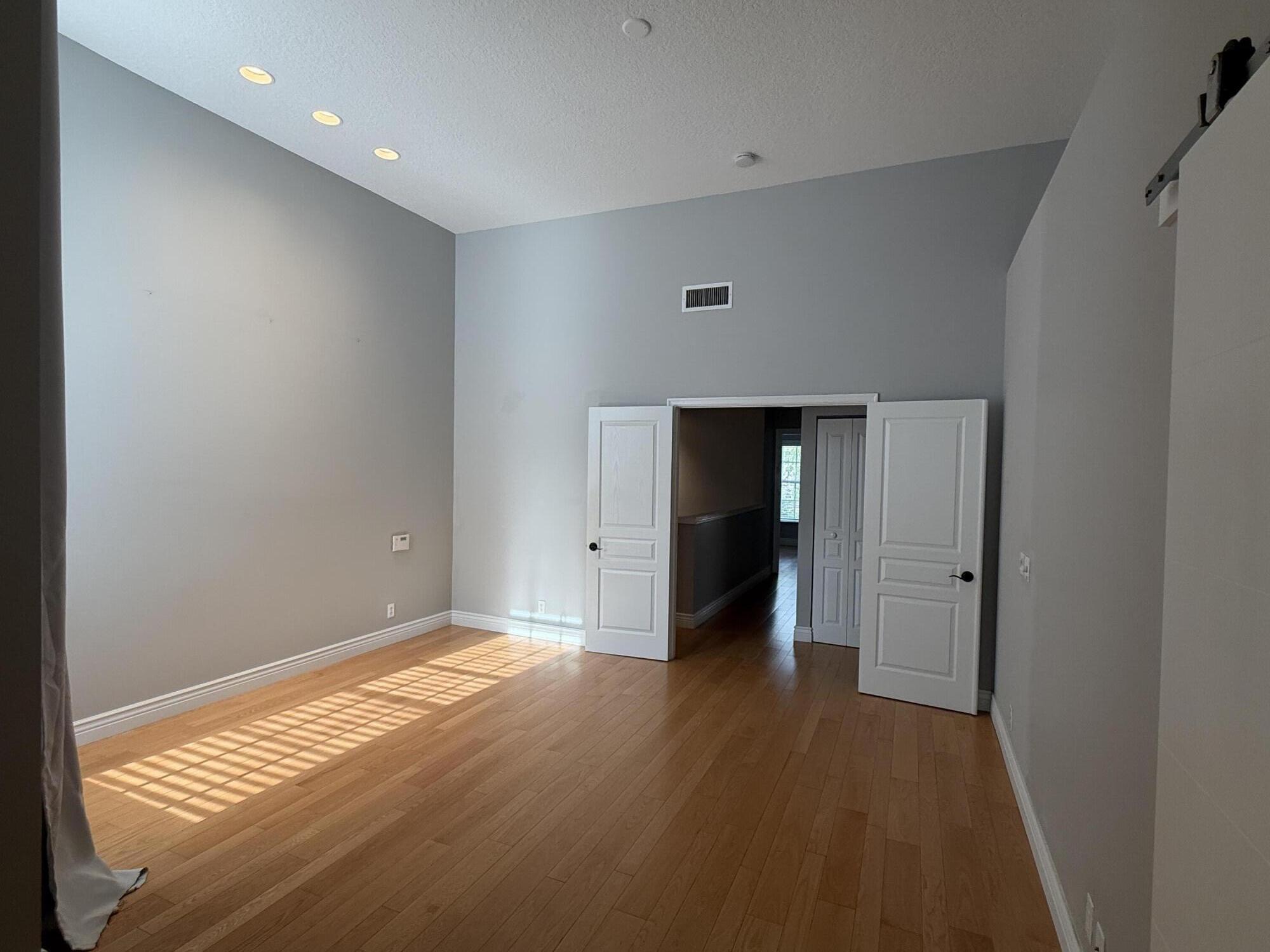 21543 St Andrews Grand Circle, Unit 41 Boca Raton, FL 33486 - Photo 15 of 27 a view of an empty room with wooden floor and closet