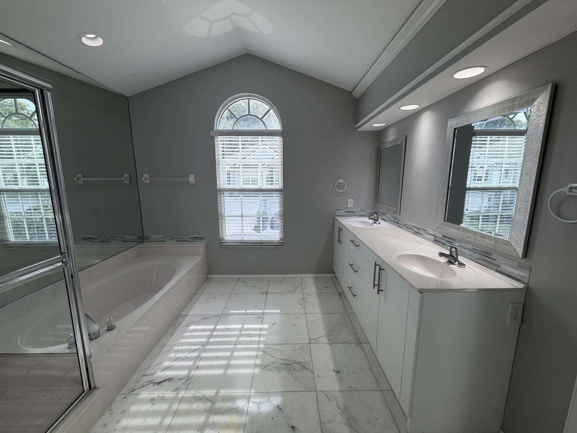 21543 St Andrews Grand Circle, Unit 41 Boca Raton, FL 33486 - Photo 16 of 27 a spacious bathroom with a bathtub sink and mirror