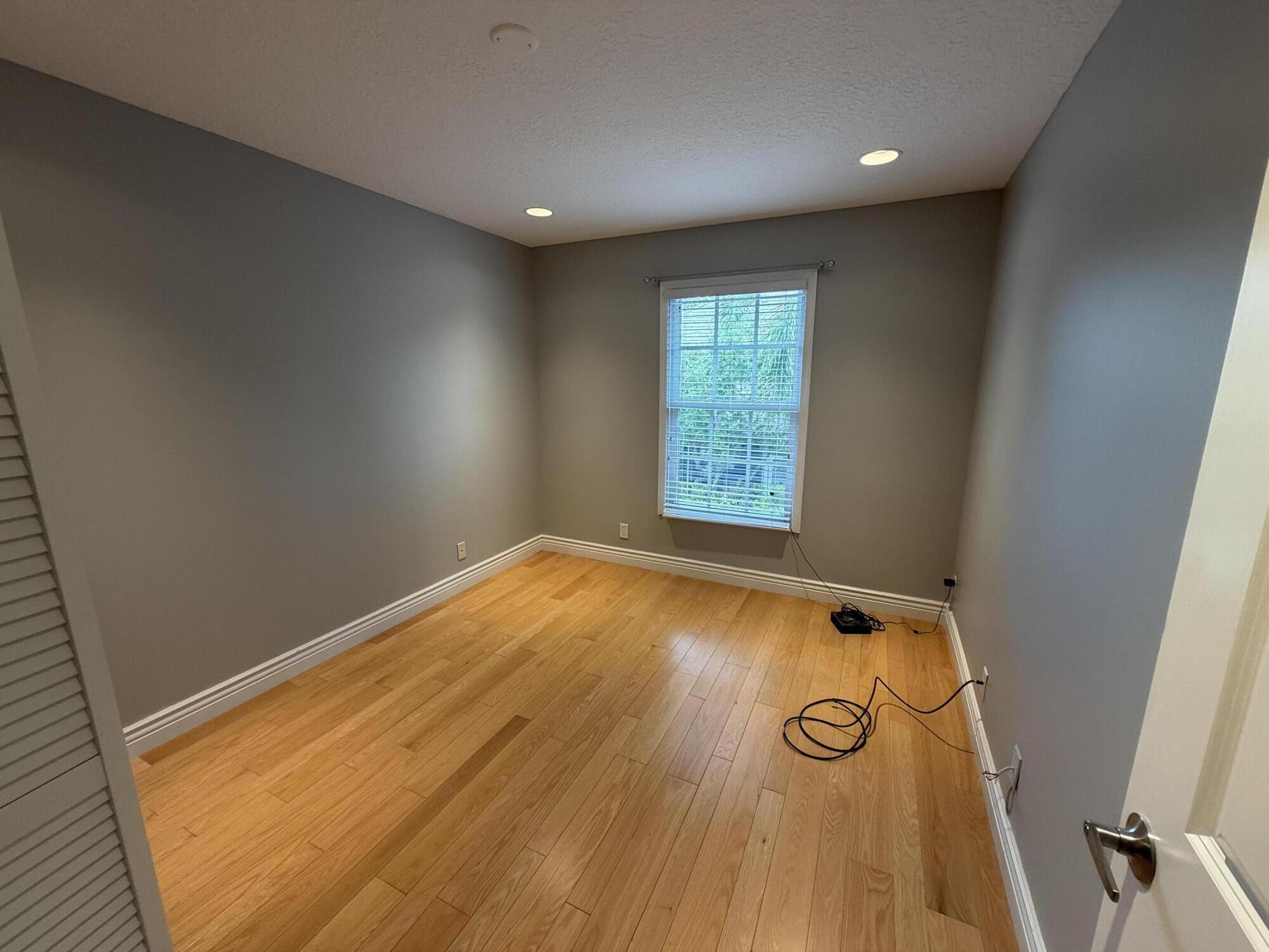 21543 St Andrews Grand Circle, Unit 41 Boca Raton, FL 33486 - Photo 23 of 27 an empty room with wooden floor and windows