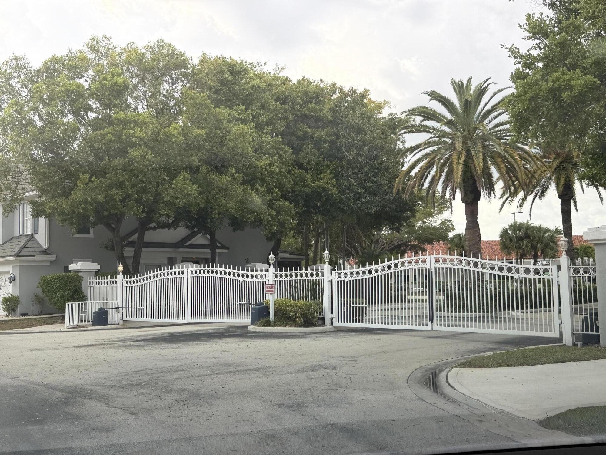 21543 St Andrews Grand Circle, Unit 41 Boca Raton, FL 33486 - Photo 27 of 27 a view of a white house with a small yard and plants