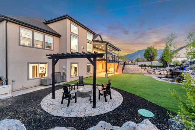 1526 South 500 West Mapleton, UT 84664 - Photo 24 of 54 Back of house at dusk featuring an outdoor fire pit, stucco siding, a patio area, and a mountain view