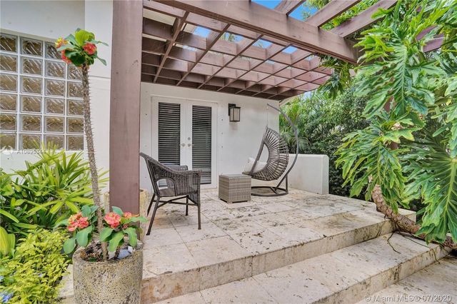 a bedroom with a bed and large windows