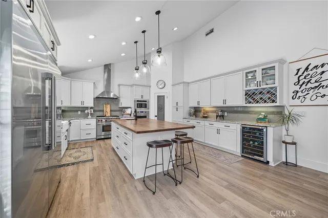 a kitchen with stainless steel appliances kitchen island granite countertop a stove a sink a refrigerator and a wooden cabinets