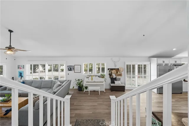 a living room with furniture and kitchen view with wooden floor