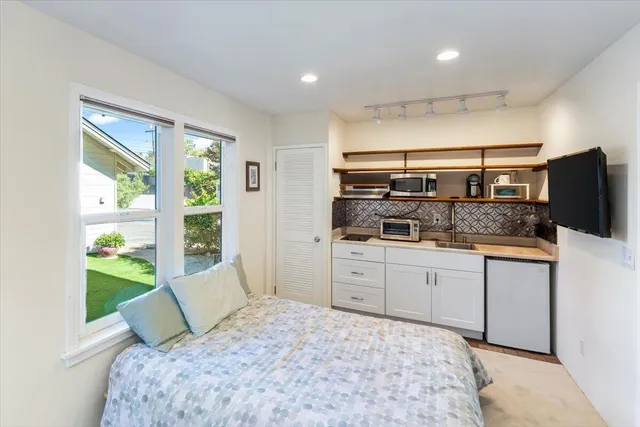 a bedroom with a large bed and a window