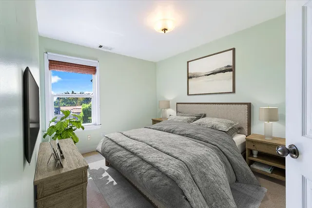 a bedroom with a bed and a potted plant