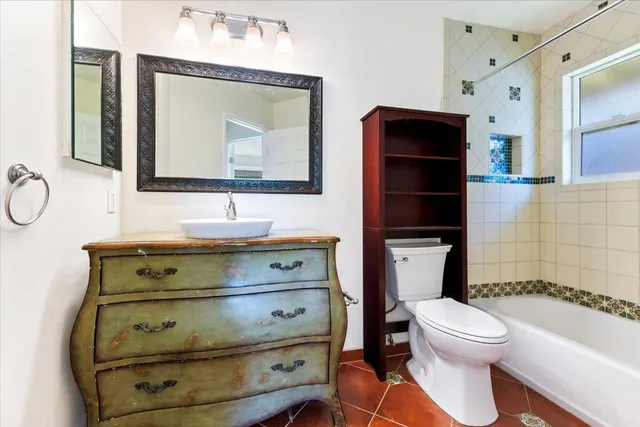 a bathroom with a toilet sink double vanity and mirror
