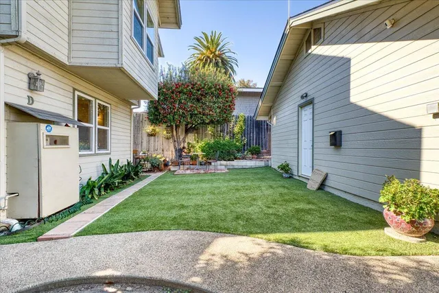 a view of a white house next to a yard
