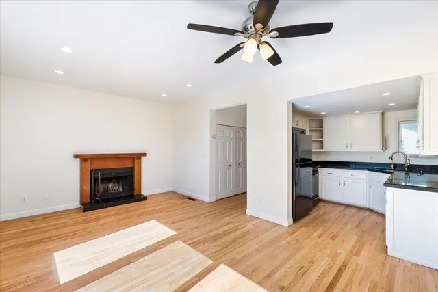 a view of a kitchen with wooden floor and a ceiling fan