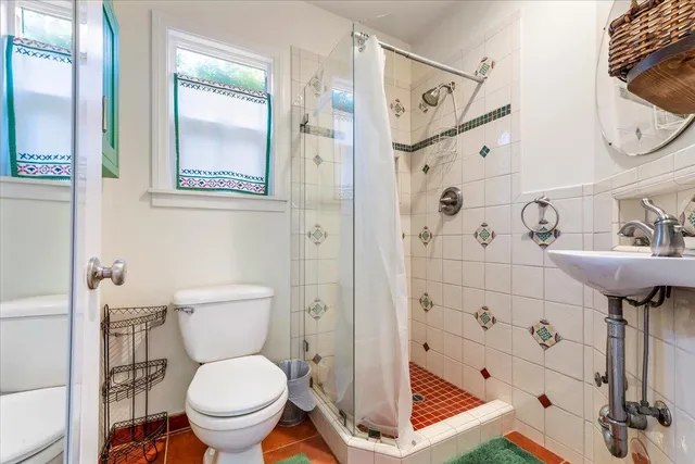 a bathroom with a toilet sink shower and mirror