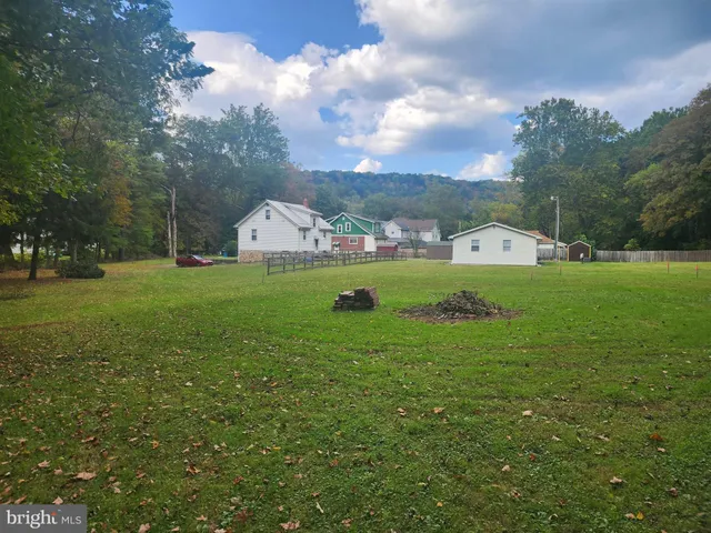 a view of a big house with a big yard and large trees