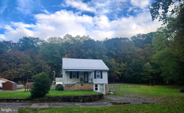 a view of a big house with a big yard and large trees