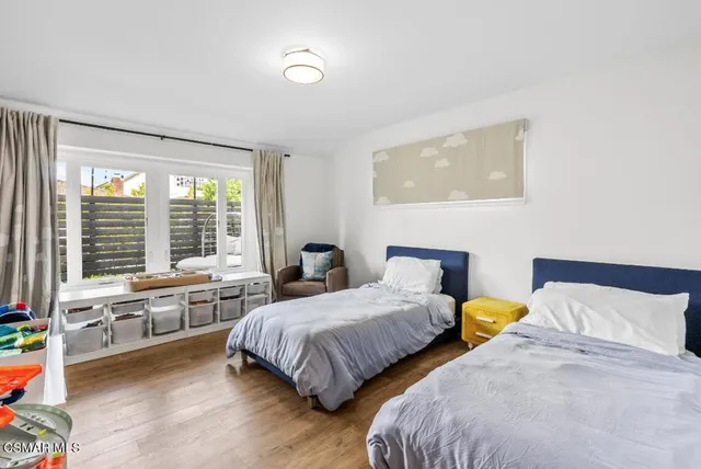 a bedroom with two beds and a large window
