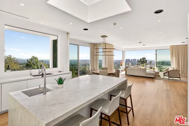 a large kitchen with kitchen island a large counter space a sink appliances and cabinets