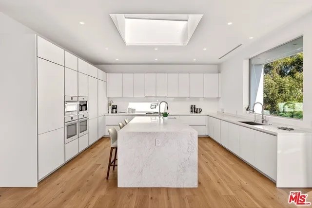 a kitchen with sink refrigerator dining table and chairs