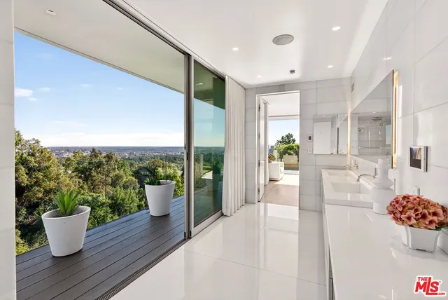 a very nice looking living room with a large window and potted plants